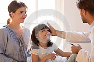 Paediatrician stroking patient girl encourages her before medical examination