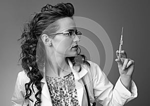 Paediatrician woman looking at syringe on