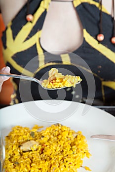 Paella in fork of woman with dress