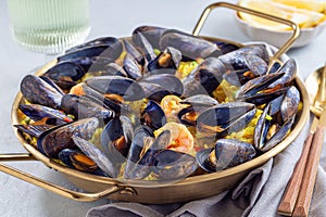 Paella with mussels and shrimps in traditional plate, horizontal