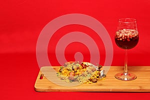 Paella rice with seafood traditional dish from Valencia Spain served on a white plate next to a pitcher of clericot with fruits an