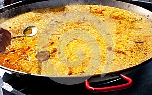 Paella rice from Valencia Spain cooking in big pan