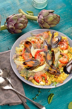 Paella with seafood. Traditional spanish food closeup on wooden table.