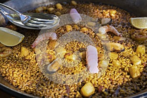 Paella traditional seafood spanish served in pan.Close up view of the famous dish with delicious ingredients prawns , squid,