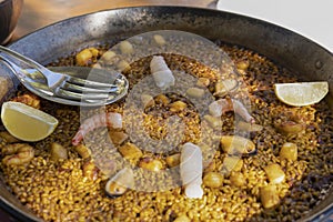 Paella traditional seafood spanish served in pan.Close up view of the famous dish with delicious ingredients prawns , squid,