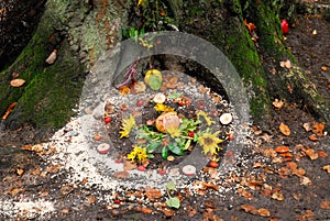 Pagan altar and spiral works outside next to a tree.