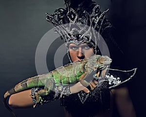 Pagan priest in ritual suit with green iguana