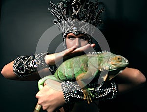 Pagan priest in ritual suit with green iguana