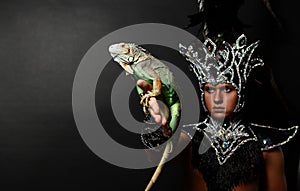 Pagan priest in ritual suit with green iguana