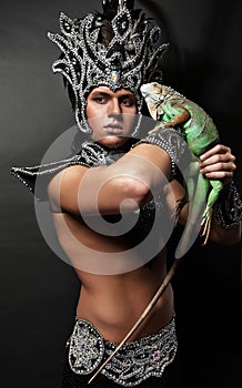 Pagan priest in ritual suit with green iguana