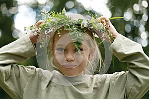 Pagan ritual, close-up portrait of a child girl with a wreath in the forest