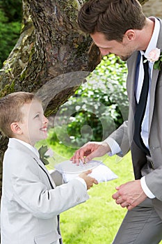Page Boy Handing Wedding Ring To Groom