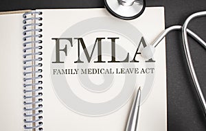 Page with FMLA Family Medical Leave Act on the table with stethoscope, medical concept
