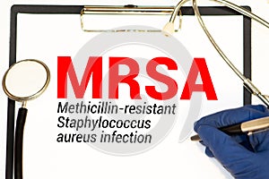 Page with MRSA Methicillin-resistant Staphylococcus aureus infection on the table with stethoscope, medical concept photo