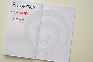 Notebook page, with text `priorities: spend less` photo
