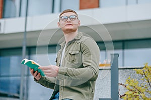 Page Turner Portrait of a Young Male with eyeglasses Sitting and Reading