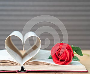 Pages of book curved heart shape and red rose