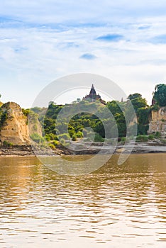 Pagoda on the bank of the Irrawaddy river, Mandalay, Myanmar, Burma. Tour from Mandalay to Bagan. Copy space for text. Vertical.