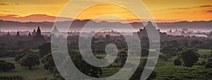 Pagoda landscape of Bagan in misty morning under a warm sunrise in the plain of Bagan Myanmar.