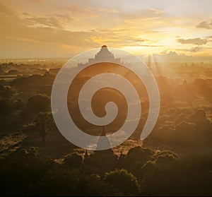 Pagoda landscape of Bagan in misty morning under a warm sunrise in the plain of Bagan Myanmar.