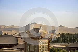 Pagoda rooftops and Singing Sand Mountain, Taklamakan Desert, Du