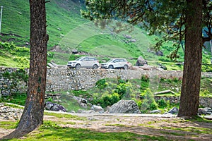 Pahalgam, Jammu & Kashmir, India: Dated- August 20, 2018: Two SUV cars parked in a health resort full of greens