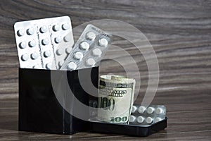 Paid medicine. Tablets and dollars in a tin can. Health care concept and health system. High medical costs and expensive treatment