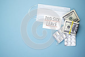 Paid sick leave with a medical mask and money on a blue background