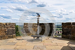 Paid single lens telescope, set on a high vantage point with a view of the city.