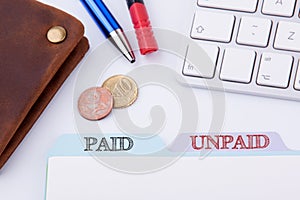 Paid and Unpaid. Folder Register on a white Office Table