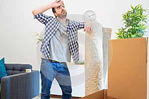 Pain in back. Young man suffering while lifting a cardboard box