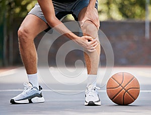 Pain, basketball and man with knee injury standing on outdoor court, holding leg. Sports, fitness and athlete with joint