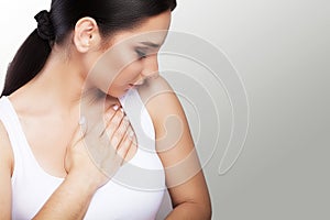 Pain. Close-up of a young woman feels severe chest pain. Close-up of a woman`s body with a hand on her chest. The girl suffers fr