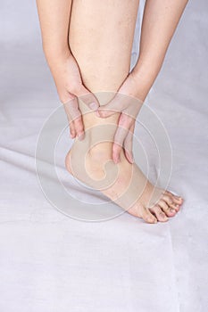 Pain concept with a woman hands catching ankle