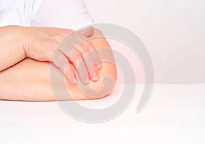 Pain in the elbow joint in a woman, tendonitis and bursitis, degenerative lesions in the joint, white background, copy space,