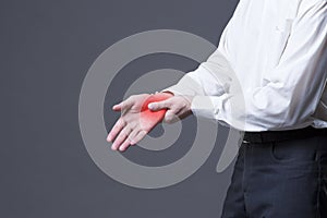 Pain in hand, joint inflammation, carpal tunnel syndrome on gray background photo