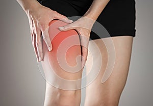 Pain in the leg of a woman. Highlighted in red. On a gray background. Close up photo