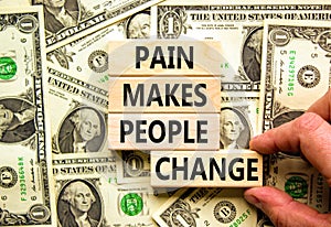Pain makes people change symbol. Concept words Pain makes people change on wooden blocks on a beautiful background from dollar