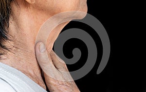 Pain at neck of Asian woman. Concept of sore throat, pharyngitis, laryngitis, thyroiditis, or dysphagia