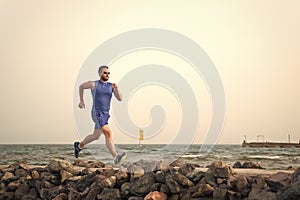 Pain is nothing compared to what it feels like to quit. Running man on beach. Runner training outdoors. Fit male sport