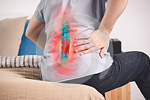 Pain in the spine, a man with backache at home, injury in the lower back