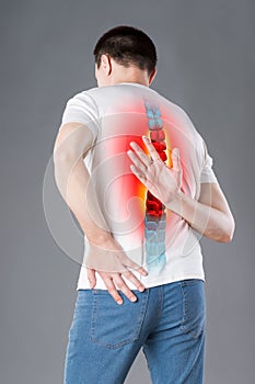 Pain in the spine, a man with backache, injury in the human back, chiropractic treatments concept