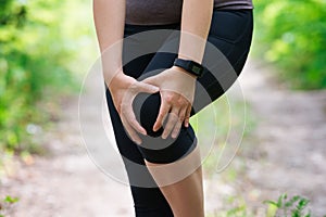 Pain in woman`s knee, massage of female leg, injury while running, trauma during workout