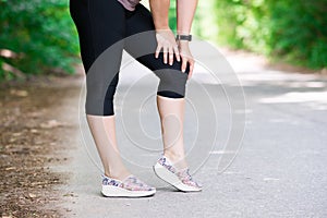 Pain in woman`s knee, massage of female leg, injury while running, trauma during workout