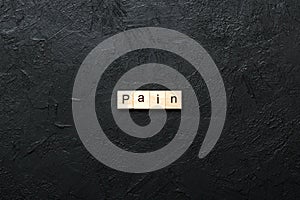 PAIN word written on wood block. PAIN text on cement table for your desing, concept