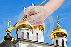 Painbrush paints golden cupola on russian church