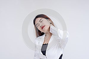 A pained young woman with tilted head holding her stiffed neck in pain. Isolated on a white background