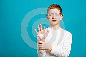Painfull boy with adhesive plaster on his hand