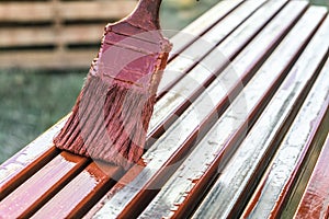 Paint application by brush on metal structures. Protective coating of steel closed profiles with primer iron oxide red