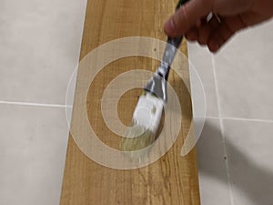 Paint the board surface with a brush from the first person.